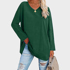 Kvinne i rosa oversized genser med V-hals, slitte jeans og beige veske. Perfekt for casual mote og trendy antrekk.